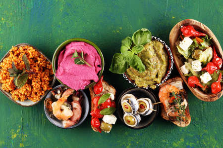 Antipasti Appetizer sweet cherry peppers stuffed with soft cheese feta, olives with oil. Seafood and anchovies with olives and dried tomatoes. Italian mediterraneの写真素材