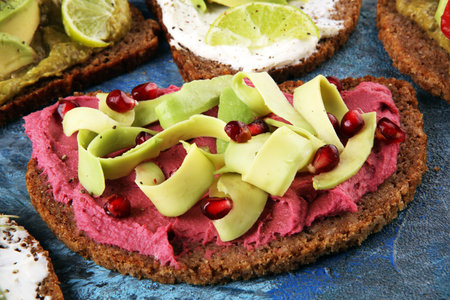 Avocado toast. Variation of healthy rye breakfast sandwiches with avocado and toppings like tomato and beetrootの写真素材