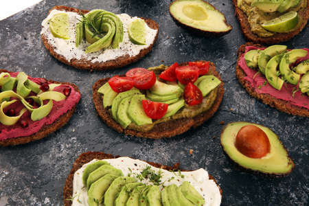 Avocado toast. Variation of healthy rye breakfast sandwiches with avocado and toppings like tomato and beetrootの写真素材