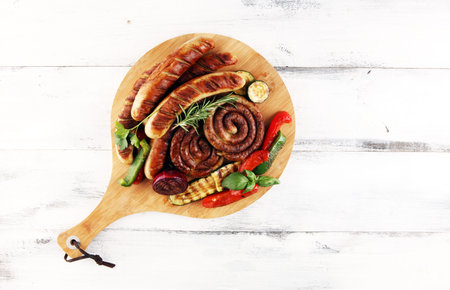 Assorted delicious grilled meat with vegetable on a barbecue with grilled sausages and vegetables....