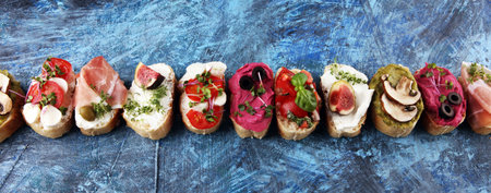 Assorted bruschetta with various toppings. Appetizing bruschetta or crudo crostini. Variety of small sandwiches. Mix bruschettaの写真素材