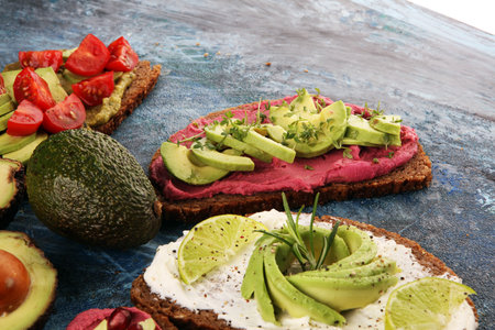 Avocado toast. Variation of healthy rye breakfast sandwiches with avocado and toppings like tomato...