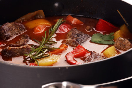 Meat stew with vegetables. Beef stew with potatoes, carrots and herbs on table. の写真素材