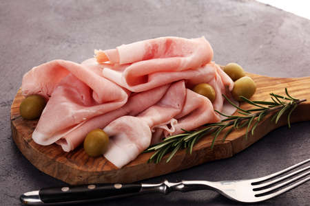 Sliced ham on wooden background. Fresh prosciutto. Pork ham sliced. meat cuttingの写真素材