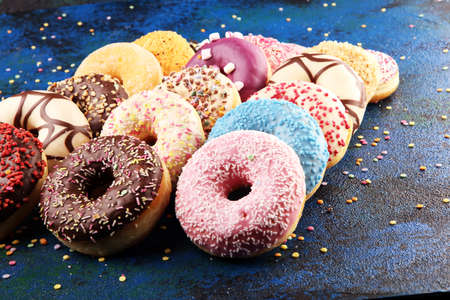 assorted donuts with chocolate frosted, pink glazed and sprinkles donuts. carnival concept with sugarの写真素材