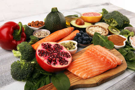 Healthy food clean eating selection: fish, fruit, vegetable, cereal, leaf vegetable on backgroundの写真素材