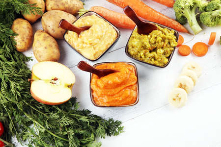 Bowls with baby food. Green, yellow and orange baby puree with fresh organic vegetablesの写真素材