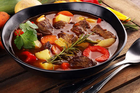 Meat stew with vegetables. Beef stew with potatoes, carrots and herbs on table. の写真素材