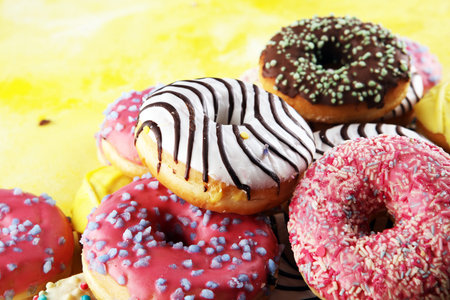 assorted donuts with chocolate frosted, pink glazed and sprinkles donuts.