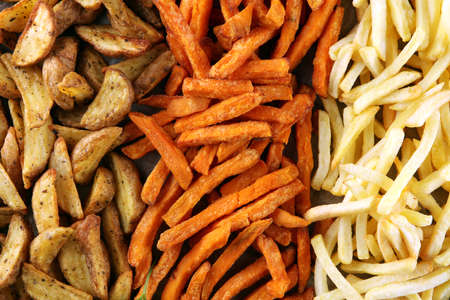 Variety of potatoes with fries. potato wedges, french fries, sweet potato for lunch on backgroundの写真素材