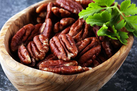 Pecan nuts on a rustic table and pecan nuts in organic bowl.の写真素材