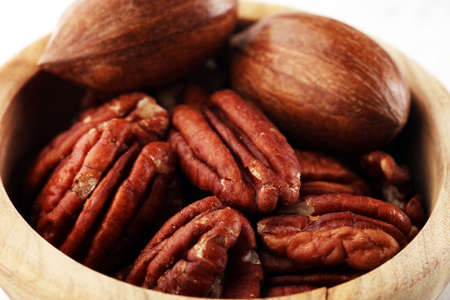 Pecan nuts on a rustic table and pecan nuts in organic bowl.の写真素材