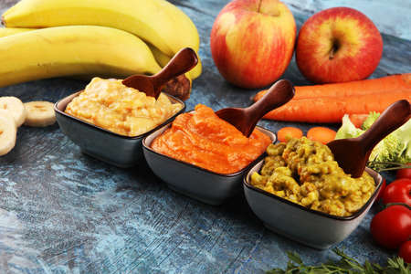 Bowls with baby food. Green, yellow and orange baby puree with fresh organic vegetablesの写真素材