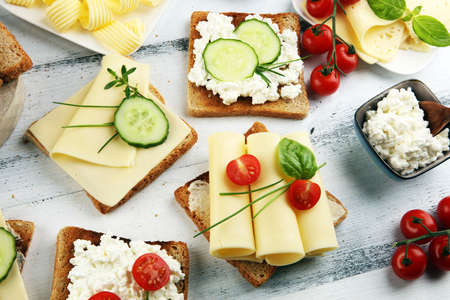 canape with yellow cheese or cream cheese and tomato. bread or toast with cheese for breakfastの写真素材