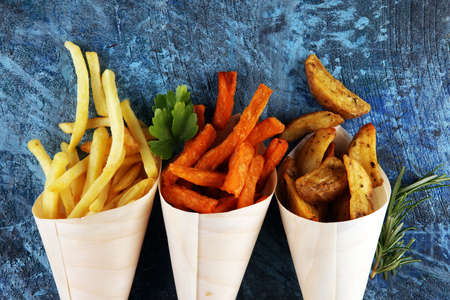 Variety of potatoes with fries. potato wedges, french fries, sweet potato for lunch on backgroundの写真素材