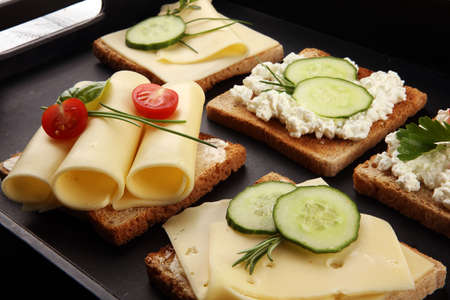 canape with yellow cheese or cream cheese and tomato. bread or toast with cheese for breakfastの写真素材