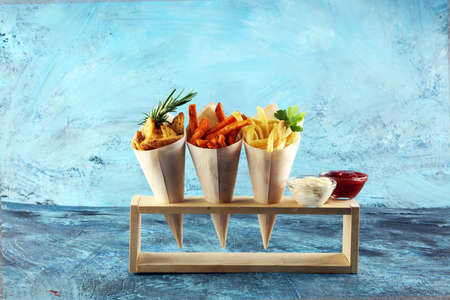 Variety of potatoes with fries. potato wedges, french fries, sweet potato for lunch on backgroundの写真素材