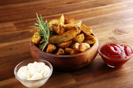 Potato wedges oven roasted with fresh thyme on rustic backgroundの写真素材