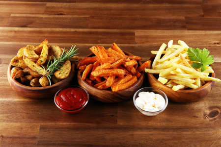 Variety of potatoes with fries. potato wedges, french fries, sweet potato for lunch on backgroundの写真素材