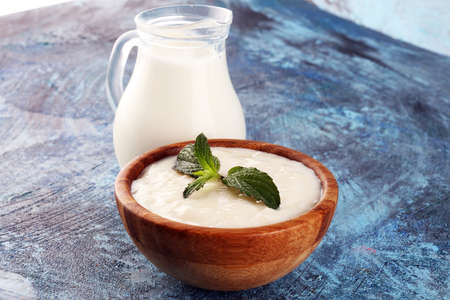 Traditional and tasty milk rice pudding with mint on rustic backgroundの写真素材