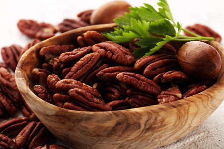 Pecan nuts on a rustic table and pecan nuts in organic bowl.の写真素材