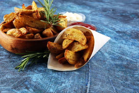 Potato wedges oven roasted with fresh thyme on rustic backgroundの写真素材