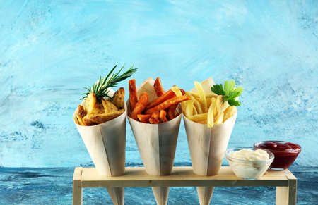 Variety of potatoes with fries. potato wedges, french fries, sweet potato for lunch on backgroundの写真素材