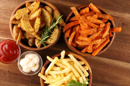 Variety of potatoes with fries. potato wedges, french fries, sweet potato for lunch on backgroundの写真素材