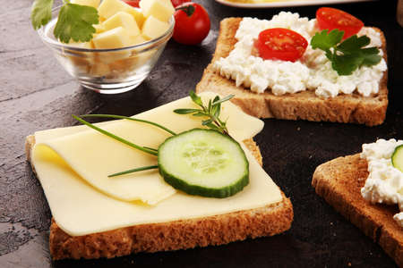 canape with yellow cheese or cream cheese and tomato. bread or toast with cheese for breakfastの写真素材
