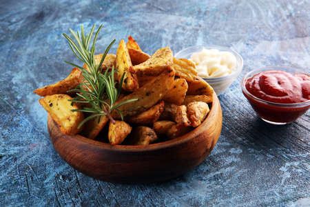 Potato wedges oven roasted with fresh thyme on rustic backgroundの写真素材