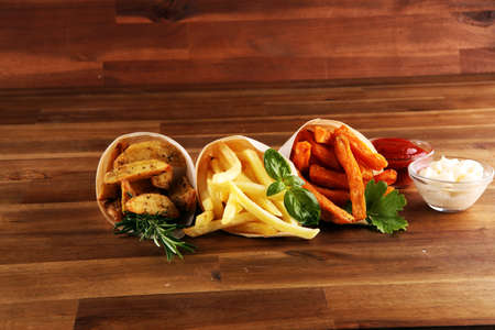 Variety of potatoes with fries. potato wedges, french fries, sweet potato for lunch on backgroundの写真素材