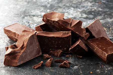 chocolate bars and broken pieces on rustic background.の写真素材