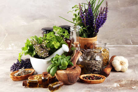 
Fresh herbs in mortar bowl from the garden and the different types of oils for massage and aromatherapy.の写真素材