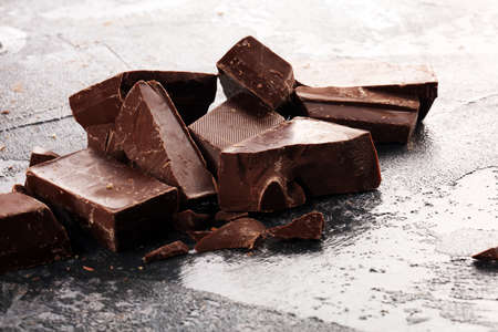 chocolate bars and broken pieces on rustic background.の写真素材