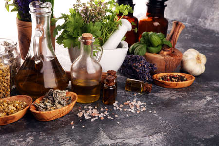 
Fresh herbs in mortar bowl from the garden and the different types of oils for massage and aromatherapy.の写真素材