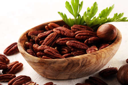 Pecan nuts on a rustic table and pecan nuts in organic bowl.の写真素材