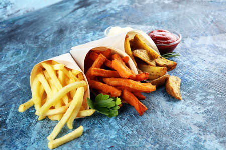 Variety of potatoes with fries. potato wedges, french fries, sweet potato for lunch on backgroundの写真素材