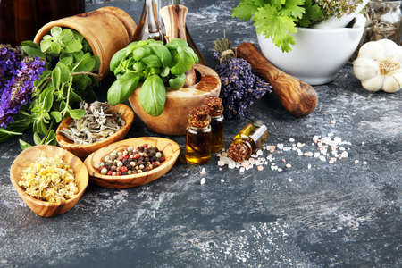 
Fresh herbs in mortar bowl from the garden and the different types of oils for massage and aromatherapy.の写真素材
