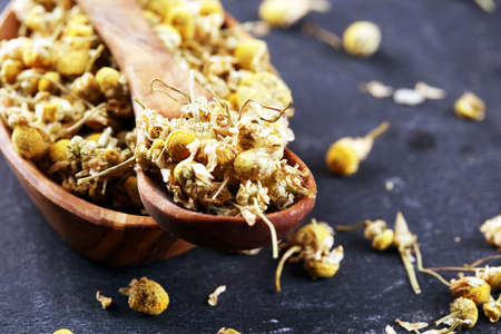Heap of dried chamomile lying on rustic surface. healthy nutrition, herbalism and alternative medicine with chamomileの写真素材