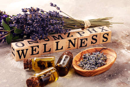 lavender herbal oil and lavender flowers. bottle of lavender massage oil for aromatherapy beauty treatment and wellness letters made of woodの写真素材