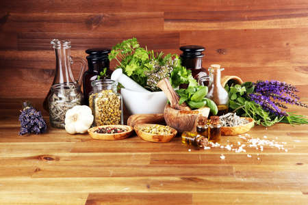 
Fresh herbs in mortar bowl from the garden and the different types of oils for massage and aromatherapy.の写真素材