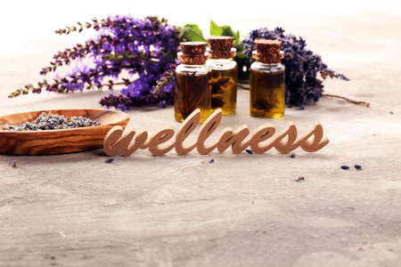 lavender herbal oil and lavender flowers. bottle of lavender massage oil for aromatherapy beauty treatment and wellness letters made of woodの写真素材