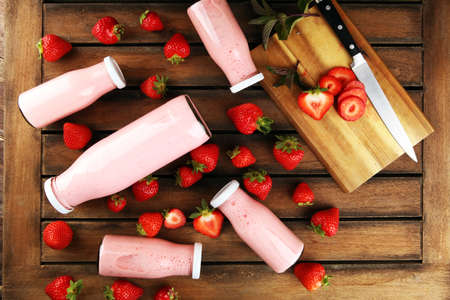 Glass of fresh strawberry shake, smoothie or milkshake and fresh strawberries on table. Healthy food and drink concept with juicy fruitsの写真素材