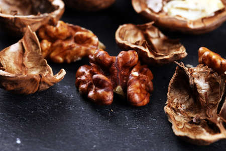 Walnut kernels and whole healthy walnuts on rustic old tableの写真素材