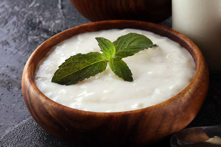 Traditional and tasty milk rice pudding with mint on rustic backgroundの写真素材