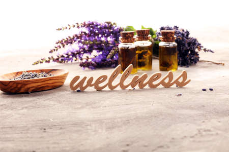 lavender herbal oil and lavender flowers. bottle of lavender massage oil for aromatherapy beauty treatment and wellness letters made of woodの写真素材