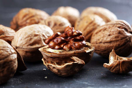 Walnut kernels and whole healthy walnuts on rustic old tableの写真素材