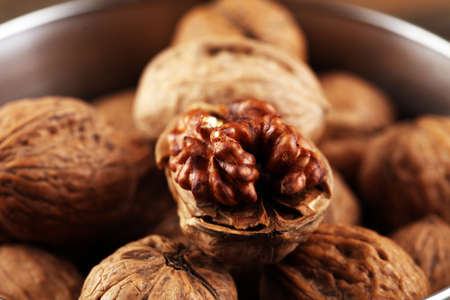 Walnut kernels and whole healthy walnuts on rustic old tableの写真素材