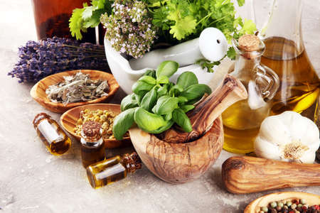 
Fresh herbs in mortar bowl from the garden and the different types of oils for massage and aromatherapy.の写真素材