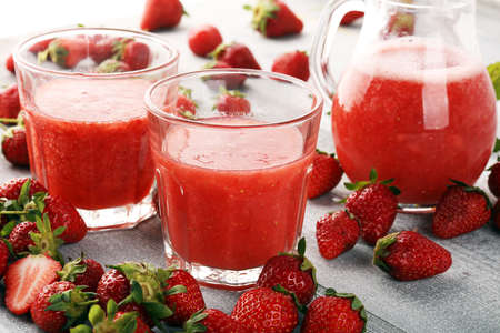 Glass of Sweet fresh strawberry juice and fresh strawberries on table. Healthy food and drink concept with fruitsの写真素材